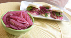 Pickled Onions in a bowl  and Hoisin Beef Bao Bun Sandwich