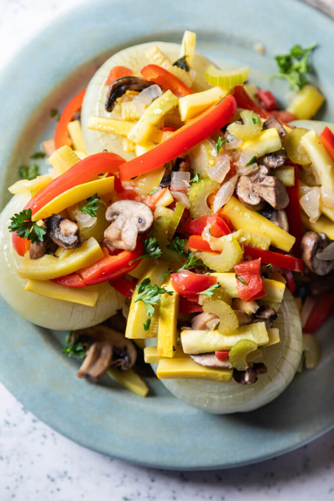 Onions stuffed with vegetables on blue plate